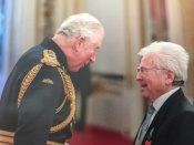 Mike in conversation with Prince Charles, now King Charles lll, at Buckingham Palace 